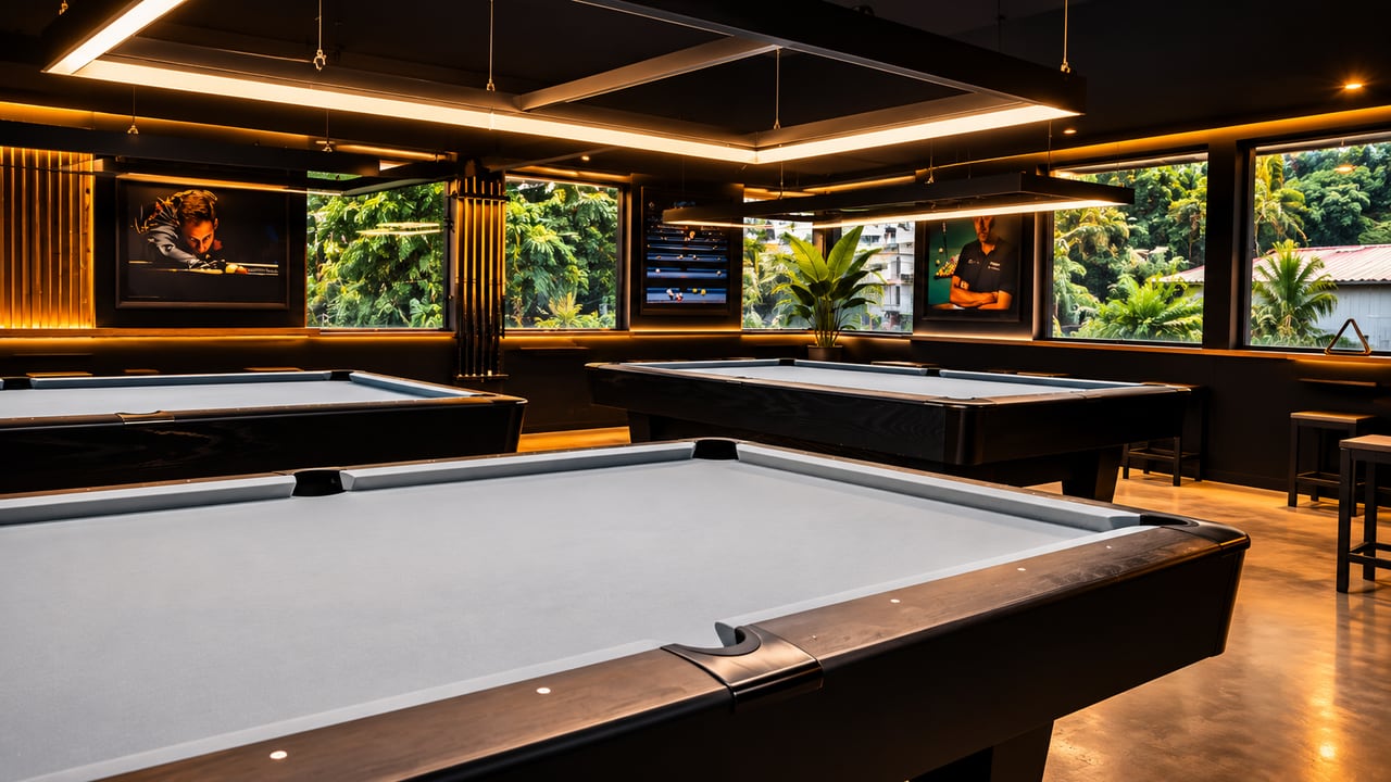 Iloilo Cue Club: grey-cloth tables under a large rectangular light, black framing, tropical trees through the windows