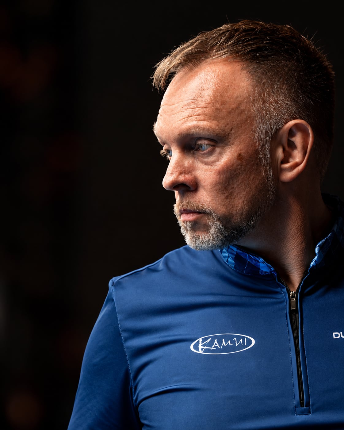 Thorsten Hohmann in profile, looking to his right, against a dark background