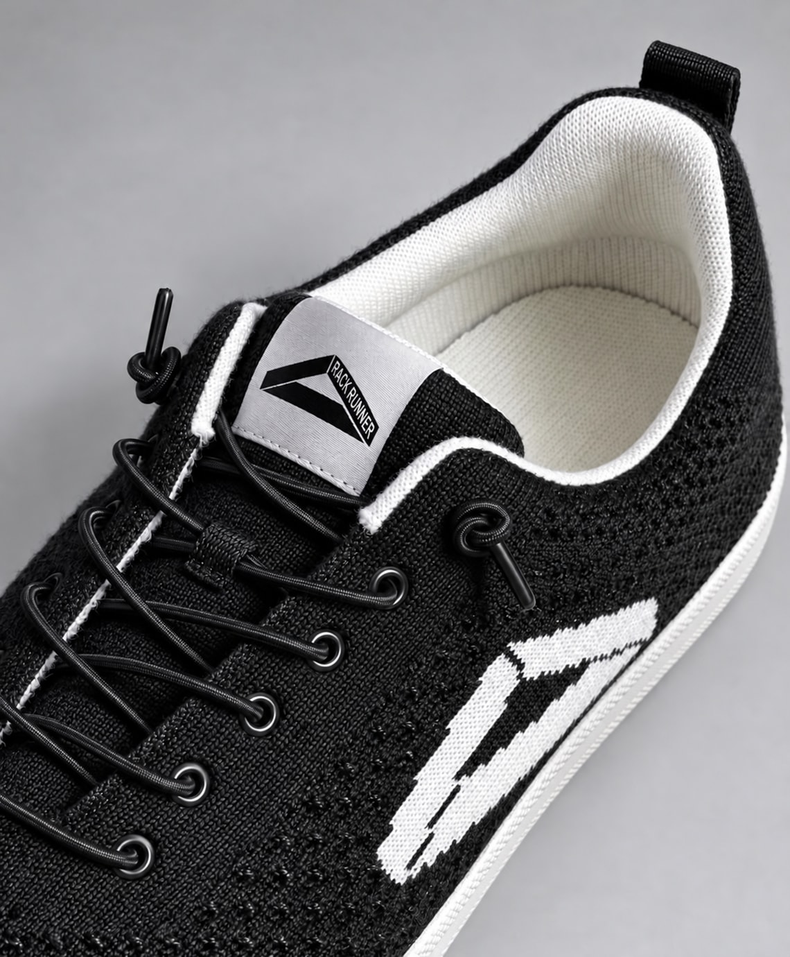 Close-up of the Rack Runner from above: knit upper, black laces and eyelets, white collar and the branded tongue label